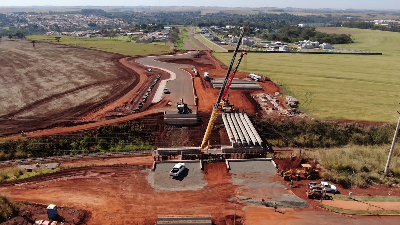 contact-img Aerial photograph showing road construction in Cidade Industrial II, Brazil, highlighting machinery and landscape.
